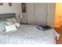 Model bedroom with attached bathroom furnished with a large bed and nightstand at Winslow House Apartments in Blackwood, NJ.