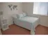 Carpeted model bedroom furnished with a bed and nightstand at Winslow House Apartments in Blackwood, NJ.