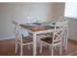 Model dining area furnished with a square table and 4 chairs at Winslow House Apartments in Blackwood, NJ.