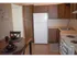 Model kitchen with wood cabinets and modern appliances at Winslow House Apartments in Blackwood, NJ.