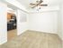 Spacious living room with carpet flooring, ceiling fan, and view into kitchen