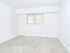 Moderate-sized bedroom with beige carpeting and window
