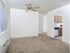 Dining area with a large window and ceiling fan looking into the kitchen at Woodland Plaza Apartments in Wyomissing, PA.