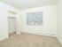 Carpeted bedroom with a large window and closet at Woodland Plaza Apartments in Wyomissing, PA.