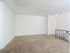 Carpeted living area with staircase to the apartment entrance at Woodland Plaza Apartments in Wyomissing, PA.