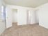 Carpeted bedroom with a large window and closet at Woodland Plaza Apartments in Wyomissing, PA.