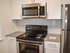 Model kitchen with stainless steel appliances and a tiled backsplash at Willow Ridge Apartments in Marlton, NJ.