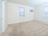 Spacious bedroom with two sizable windows and air conditioning unit