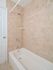 Brown tiled bathroom shower with white tub in Phoenixville, PA apartment for rent