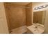 Tiled bathroom with tub shower and vanity sink at Mill Creek Village apartments in Langhorne, PA.