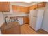 Kitchen with wood-style flooring and modern appliances at Mill Creek Village apartments in Langhorne, PA.