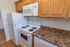 Kitchen with granite countertops and white appliances at Allandale Village apartments for rent