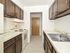 Galley kitchen with tile flooring and wood cabinets