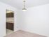 Carpeted dining room with white walls and hanging light fixture