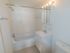 Bathroom with white tile and a vanity mirror at Gayley Park apartments for rent