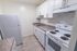 Galley kitchen with white appliances and marbled contemporary backsplash