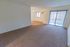 Carpeted living room with sliding glass balcony doors at Whiteland West Apartments in Exton, PA.