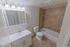 Bathroom with a bathtub, cabinet, and toilet at Caln East apartments for rent