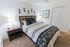 Decorated bedroom complete with a bed and side tables at Black Hawk apartments for rent