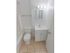 Tiled bathroom with a tub shower, toilet and sink with vanity at Mayflower Crossing Apartments in Wilkes-Barre, PA.