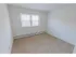 Large windows in a carpeted bedroom at Mayflower Crossing Apartments in Wilkes-Barre, PA.