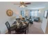 Furnished sample dining area with a circle table and 4 chairs looking into the living room at Mayflower Crossing Apartments.