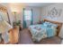 Model bedroom furnished with a large bed, dresser and nightstand at Mayflower Crossing Apartments in Wilkes-Barre, PA.
