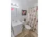 Tiled bathroom with a tub shower, toilet and sink with vanity at Mayflower Crossing Apartments in Wilkes-Barre, PA.