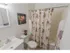 Tiled bathroom with a tub shower, toilet and sink with vanity at Mayflower Crossing Apartments in Wilkes-Barre, PA.