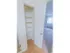 Kitchen pantry with several shelves and view in to carpeted living room