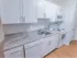 Renovated kitchen with white cabinets and contemporary tile backsplash