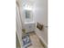 White sink and vanity with overhead lighting and medicine cabinet in apartment bathroom