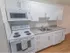 Renovated kitchen with white appliances and cabinets