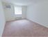 Apartment bedroom with carpet flooring and air conditioning unit