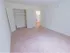 Large bedroom with sizable closet and carpeted floors with view into kitchen