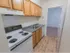 Galley kitchen with brown cabinets and white appliances