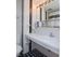 Black and white master bathroom with large mirror and white sink