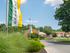 Entrance to Woodbury, NJ townhome community with landscaping and green and yellow leasing flags