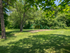 Swings and jungle gym surrounded by grass and trees in townhome community