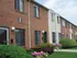 Exterior of red brick townhomes with neat landscaping and colorful flowers
