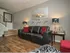 Furnished apartment living room with hardwood flooring and stairs to second floor