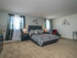 Large master bedroom with two windows and carpet flooring in Woodbury, NJ townhome for rent