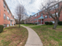 Sidewalk between two long buildings with covered exterior entrances at Evergreen Club apartments for rent in Broomall, PA