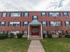 Exterior of residential buildings with red door and dark shutters at Evergreen Club apartments for rent