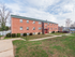 Red brick residential building outside on a sunny day at Evergreen Club apartments for rent in Broomall, PA