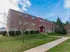 Exterior of a residential building with sculpted bushes and a grassy lawn at Evergreen Club apartments for rent in Broomall, PA