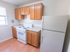 Kitchen with brown cabinets and white appliances at Evergreen Club apartments for rent in Broomall, PA
