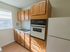 Wooden cabinets in a sunny kitchen with a window at Evergreen Club apartments for rent in Broomall, PA