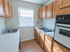 Kitchen with a vintage stovetop, oven, and large window at Evergreen Club apartments for rent