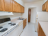 Kitchen with brown cabinets and tile flooring at Evergreen Club apartments for rent